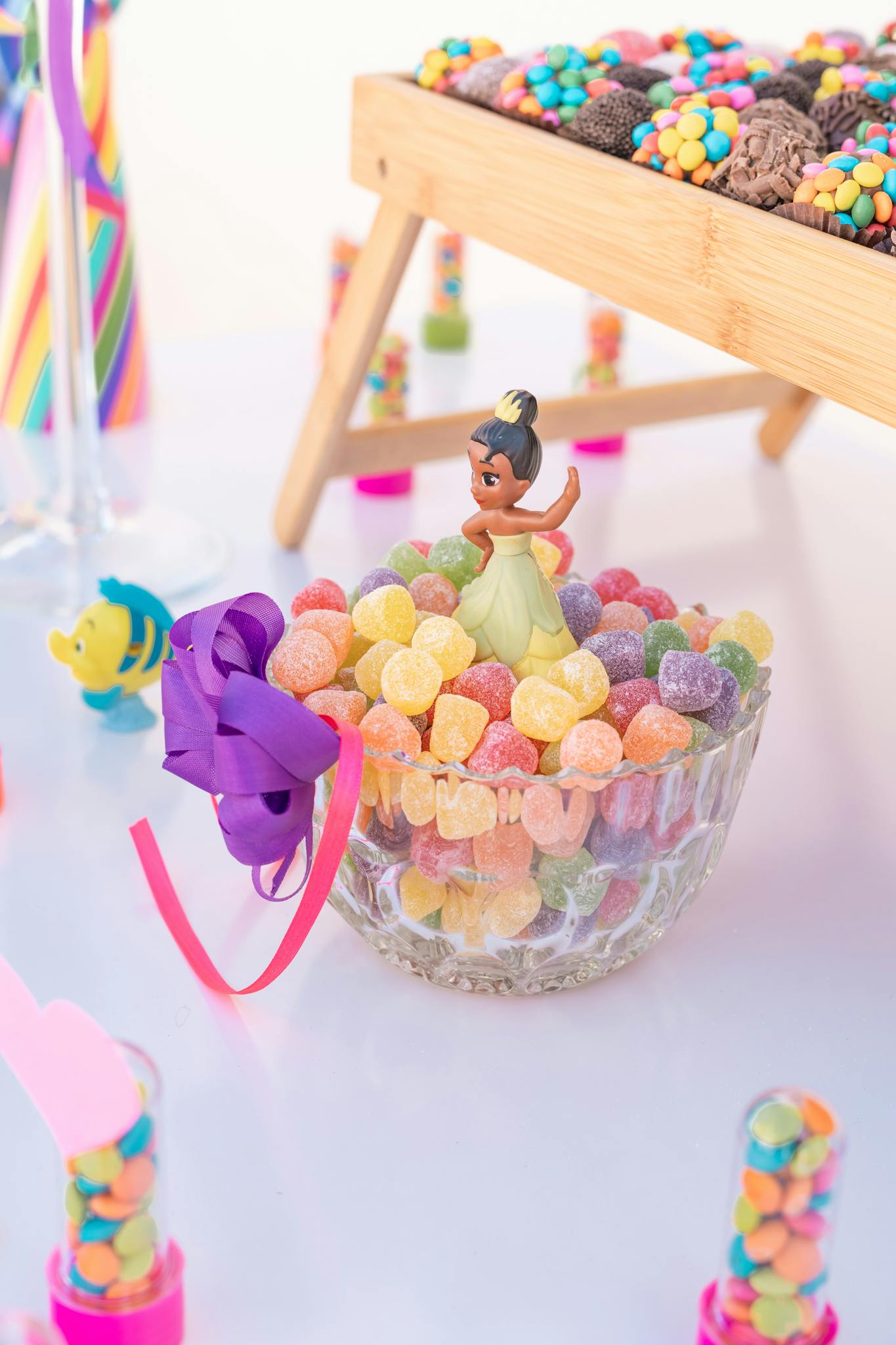 Colorful candy display with a figurine centerpiece at a festive party setting.